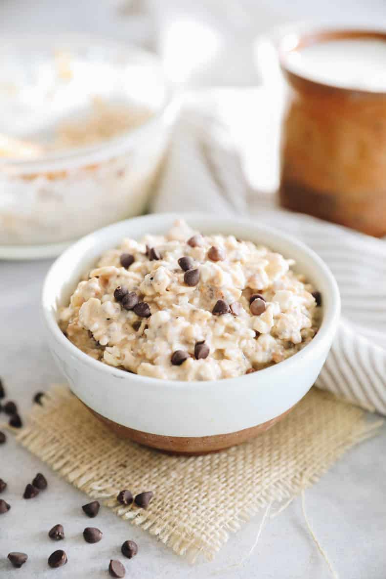 Cottage cheese cookie dough overnight oats in a brown and white bowl with chocolate chips.