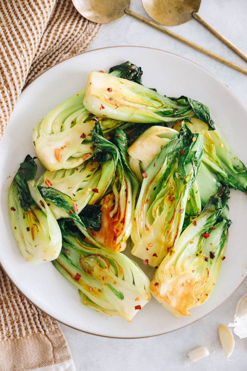 Garlic baby bok choy recipe stacked on a plate.