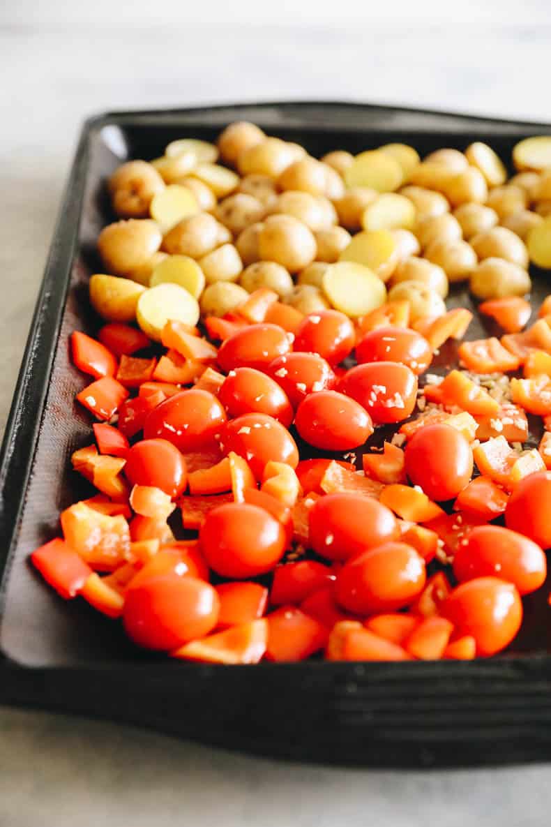 tomatoes, peppers and potatoes on a sheet pan.
