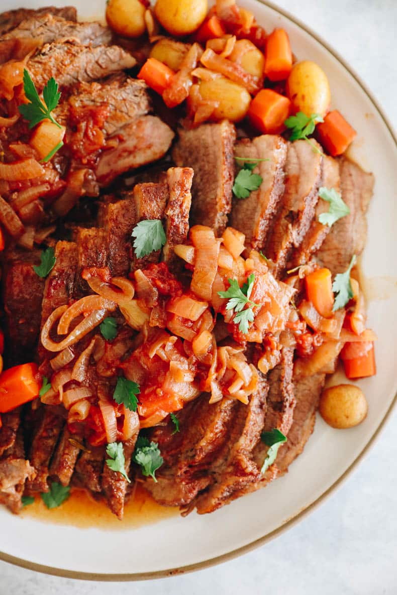 overhead image of brisket with caramelized onions, potatoes and carrots