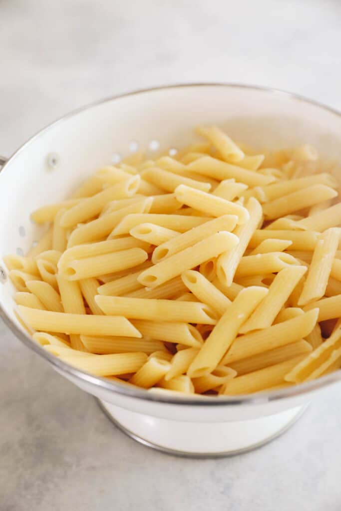 penne pasta in a white colander.