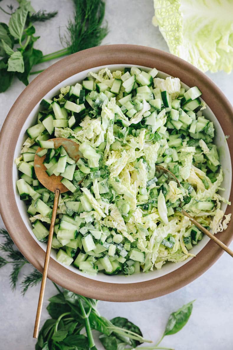 green goddess salad in a white and brown bowl.